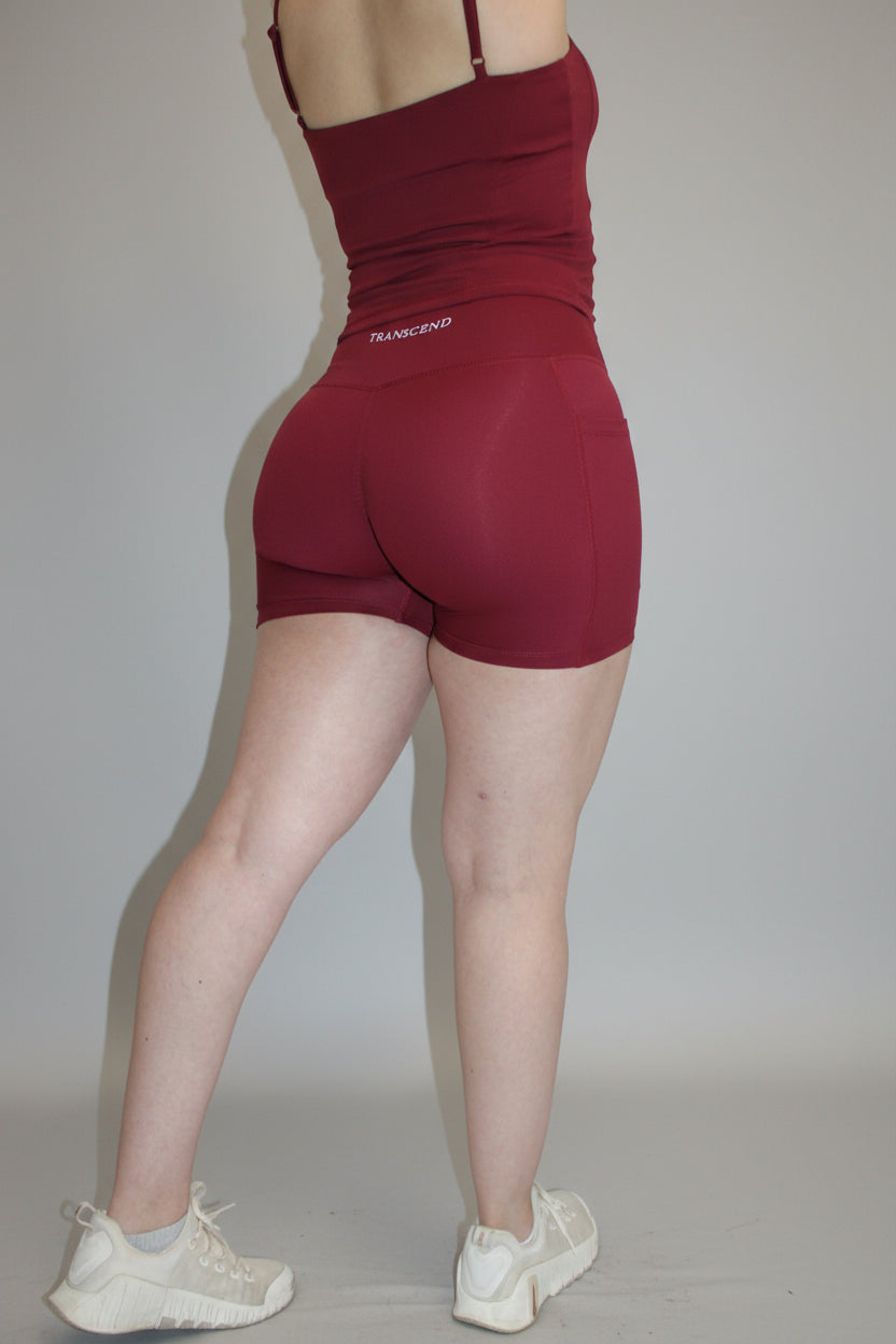 Person wearing red shorts and tank top on a white background