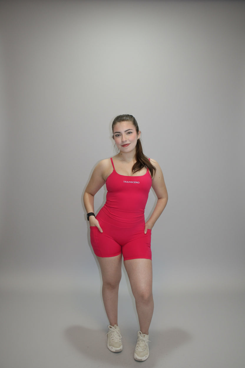 Person in a pink outfit standing on a white back drop at a studio