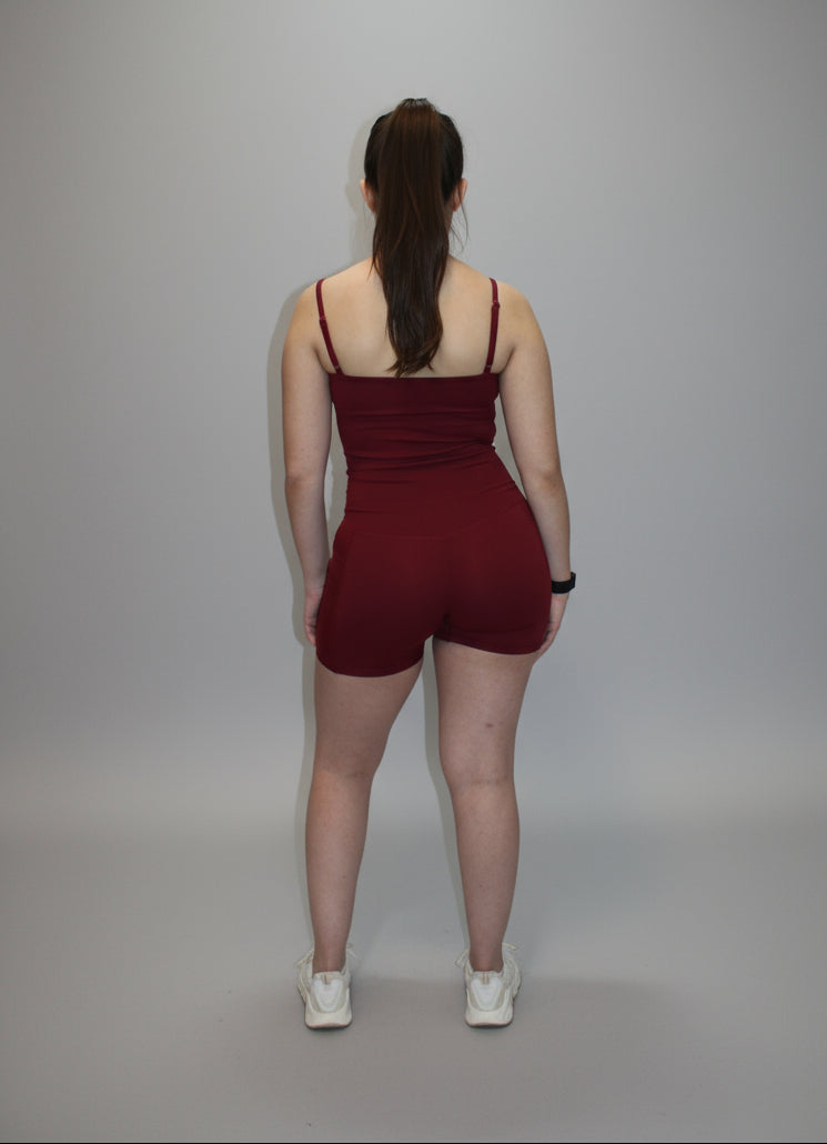 Person wearing a red tank top and shorts standing on a white sheet