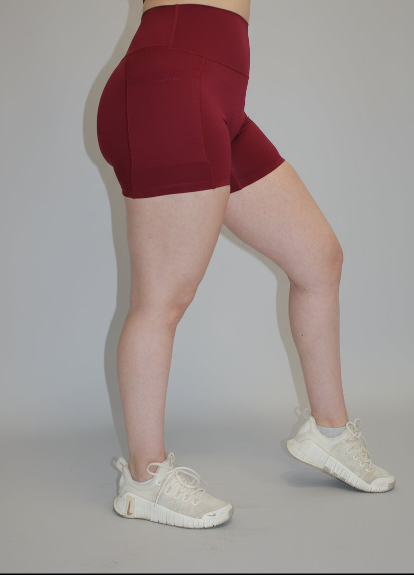 Person wearing red shorts and white sneakers on a white background