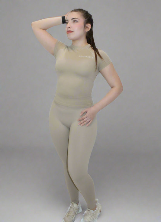 Woman wearing beige activewear set with logo on white background