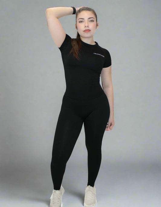 Person wearing a black athletic outfit with a logo on a white background